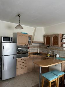 Il comprend une cuisine équipée d'un réfrigérateur en acier inoxydable et d'une table en bois. dans l'établissement Cosy apartment-private parking, à Zagreb