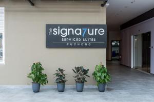 un cartel en un edificio con macetas. en The Signature Serviced Suites Puchong en Puchong