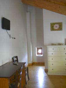 a room with a desk and a dresser with a television at Locanda Incantata Room & Relax in Scurcola Marsicana