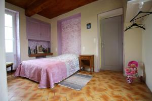 1 dormitorio con cama rosa y suelo de madera en Au bon vivre, en Saint-Orens-Pouy-Petit