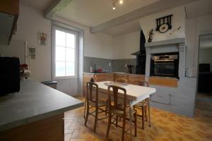 cocina con mesa y sillas en una habitación en Au bon vivre, en Saint-Orens-Pouy-Petit