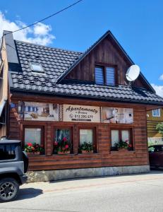 a wooden building with flowers in the windows at Apartamenty u Grażyny in Kluszkowce