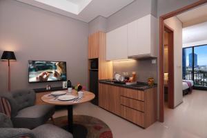 a kitchen and living room with a table in a room at Citadines Gatot Subroto Jakarta in Jakarta