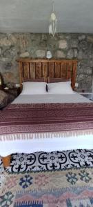 1 dormitorio con cama de madera en una habitación en Stone Cottage garden, terrace sea and forest view en Marmaris