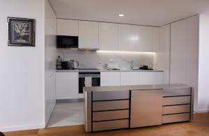 a kitchen with white cabinets and a counter top at Porto Sunset suite in Vila Nova de Gaia +18 photos