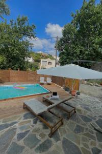 a large white umbrella sitting next to a swimming pool at Loft for travellers in Vasilikí