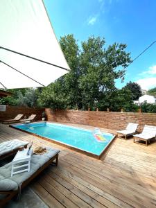 a swimming pool on a wooden deck with an umbrella at Loft for travellers in Vasilikí