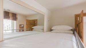 biała sypialnia z 2 łóżkami i lustrem w obiekcie Castle House - Polruan w mieście Polruan