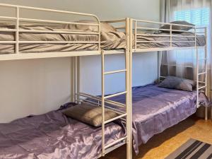 1 Schlafzimmer mit 2 Etagenbetten und 1 Bett in der Unterkunft Holiday home NYNÄSHAMN in Nynäshamn