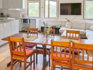 cocina y sala de estar con mesa de madera y sillas en Holiday home NYNÄSHAMN, en Nynäshamn