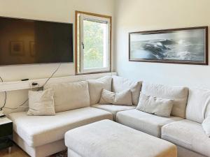 Holiday home NYNÄSHAMN في نينس هامن: غرفة معيشة مع أريكة بيضاء وتلفزيون بشاشة مسطحة