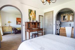 una camera da letto con un letto, una scrivania e un bagno di Le Clos des Senteurs de Chateauneuf de Grasse a Châteauneuf Altre 97 foto