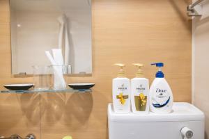 a bathroom with three bottles of cleaning products on top of a toilet at H2H Dotonbori in Osaka