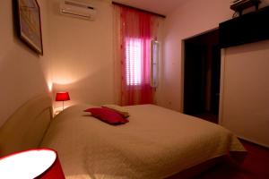 a bedroom with a bed and a lamp at Apartments and Rooms Dis in Vis