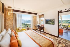 a hotel room with a bed and a large window at Vivanta Jammu City Centre in Jammu