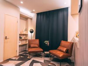 大阪的住宿－R Hotel-The Atelier Shinsaibashi East，两把椅子放在一个有蓝色窗帘的等候室