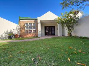 a house with a lawn in front of a building at Siena Sun Apartment 4 in Midrand