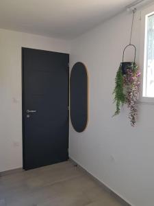 - une porte noire dans une pièce blanche avec un miroir dans l'établissement Excellent logement proche Paris, à Sceaux