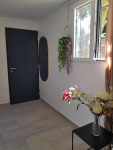 a hallway with a black door and a vase of flowers at Excellent logement proche Paris in Sceaux