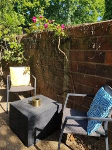 a patio with two chairs and a table and a wall at Excellent logement proche Paris in Sceaux