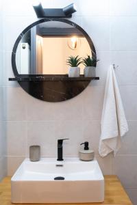 bagno con lavandino bianco e specchio di Stylish Apartment Xanthi - MenoHomes 5 a Xánthi