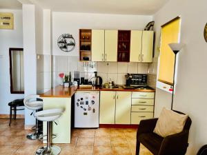 a kitchen with yellow cabinets and a white refrigerator at Milinovic apartmani3 in Herceg-Novi