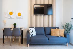 uma sala de estar com um sofá azul e uma mesa em Stylish Apartment Xanthi - MenoHomes 5 em Xanthi