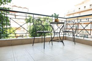 Duas cadeiras e uma mesa numa varanda em Stylish Apartment Xanthi - MenoHomes 5 em Xanthi