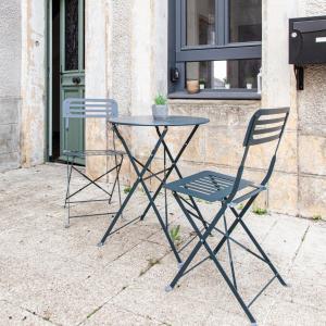 una mesa y dos sillas sentadas junto a un edificio en Jolie m'Home*Le Puy du Fou, en Mauléon