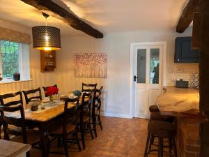a dining room with a wooden table and chairs at New Forest Spacious Family House in New Milton