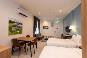 a hotel room with two beds and a table at The Signature Serviced Suites Puchong in Puchong
