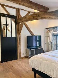 Schlafzimmer mit einem Bett und einem Flachbild-TV in der Unterkunft Le Domaine de Darracq in Arsagne