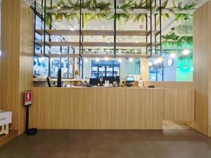 an office lobby with a large wooden reception desk at The Ellis Bangkok in Makkasan