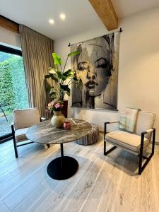 un soggiorno con tavolo, sedie e un dipinto di Via Caput a Lokeren