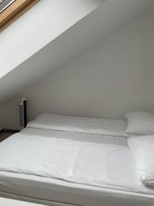 a white bed with white sheets and pillows at KHAN Apartments LJUBLJANA in Ljubljana