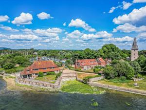 an aerial view of a town with a church and a river at Pass the Keys Historic Waterfront Home in Bosham in Bosham