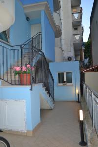un edificio azul con escaleras y macetas de flores en Residence Blu Marine, en Rímini