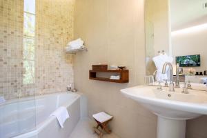 a bathroom with a sink and a bath tub and a sink at Hotel Château Des Alpilles in Saint-Rémy-de-Provence