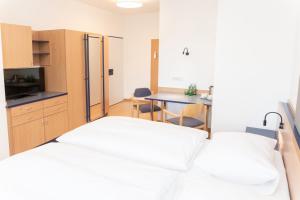 Zimmer mit 2 Betten, einer Küche und einem Tisch in der Unterkunft JUFA Hotel Garni Stubenberg in Stubenberg
