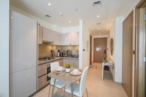 una cucina e una sala da pranzo con tavolo e sedie di Bright Apartment With Panoramic CityScape Views a Dubai