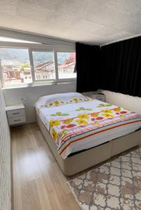 una camera da letto con un letto con una coperta a fiori di Deniz manzaralı lüks çatı katı (Loft ,penthouse) a Fethiye