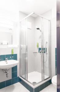 a bathroom with a shower and a sink at JUFA Hotel Garni Stubenberg am See in Stubenberg