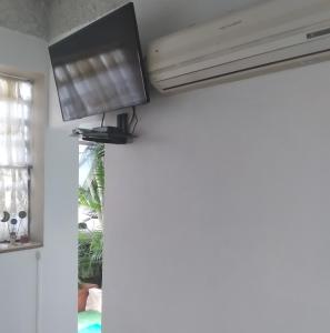 a television hanging from a ceiling in a living room at Studio SUITE M&J in Caracas