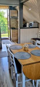 jadalnia ze stołem i krzesłami oraz kuchnia w obiekcie Apartamenty u Grażyny w Kluszkowcach