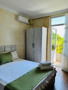a bedroom with a bed with a cabinet and a window at Apartments NITA in Batumi