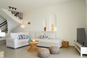 a living room with a white couch and a table at Meneou Houses by the Sea in Larnaka