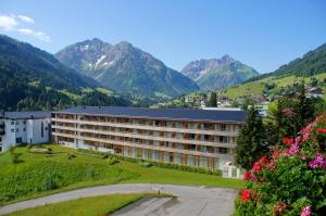 a hotel in a valley with mountains in the background at Sporthotel Walliser in Hirschegg