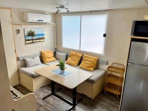 una pequeña sala de estar con sofá y mesa. en Mobilehome Adams Glamping - Camp Adriatic en Primošten
