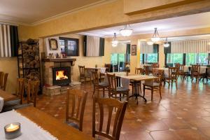 a restaurant with tables and chairs and a fireplace at Guest House Valevtsi in Valevtsi