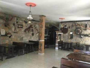un restaurant avec des tables en bois et un mur en pierre dans l'établissement Hotel PRINC, à Velipojë